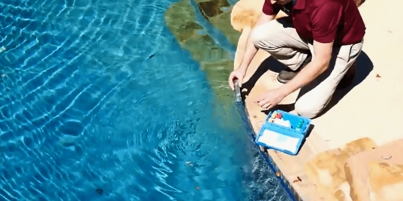 a certified pool and spa professional cleaning a homeowner’s pool